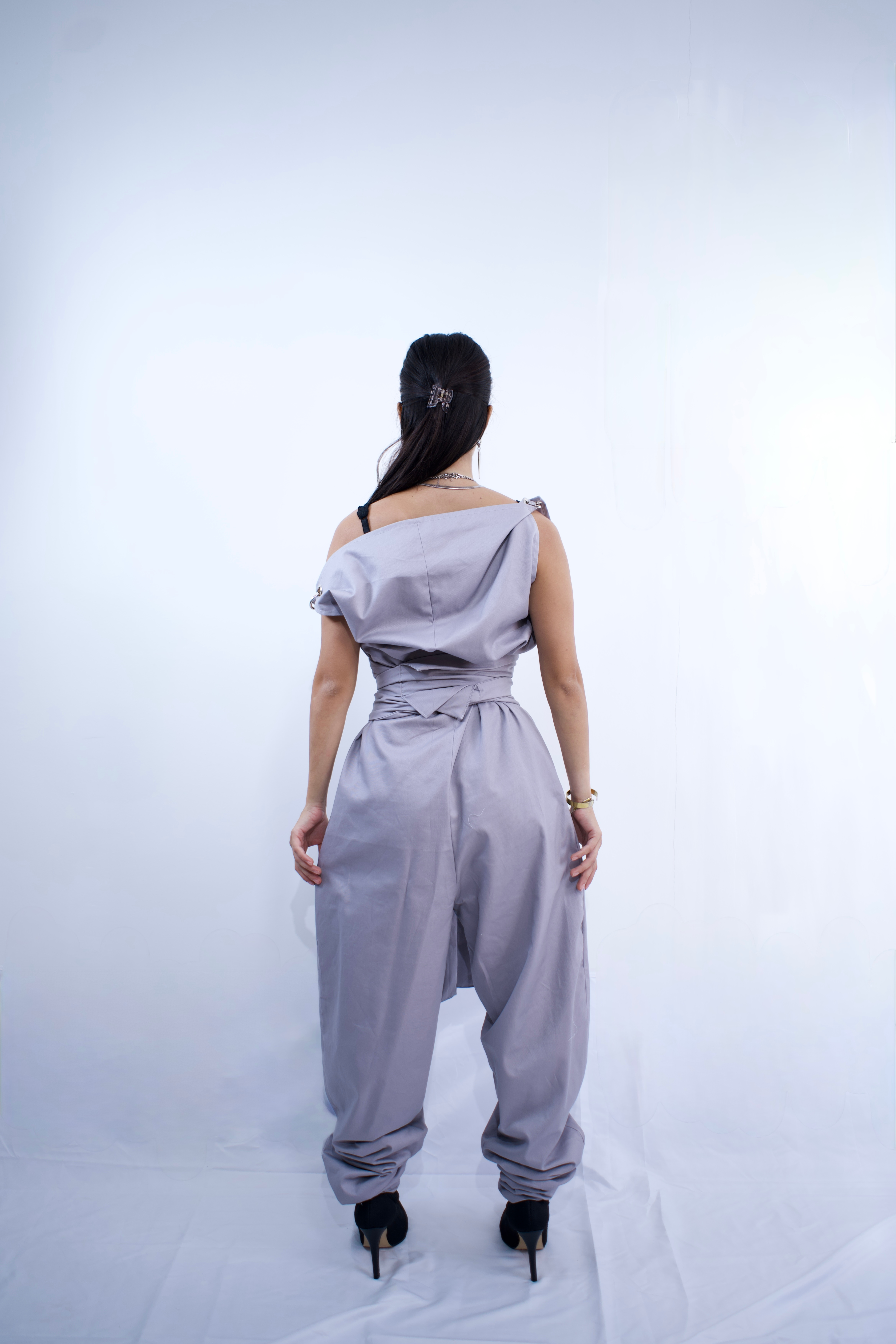 Switch Jumpsuit by MVATIS a convertible jumpsuit that transforms into sleek trousers with adjustable belt detail for cinched waist effect.