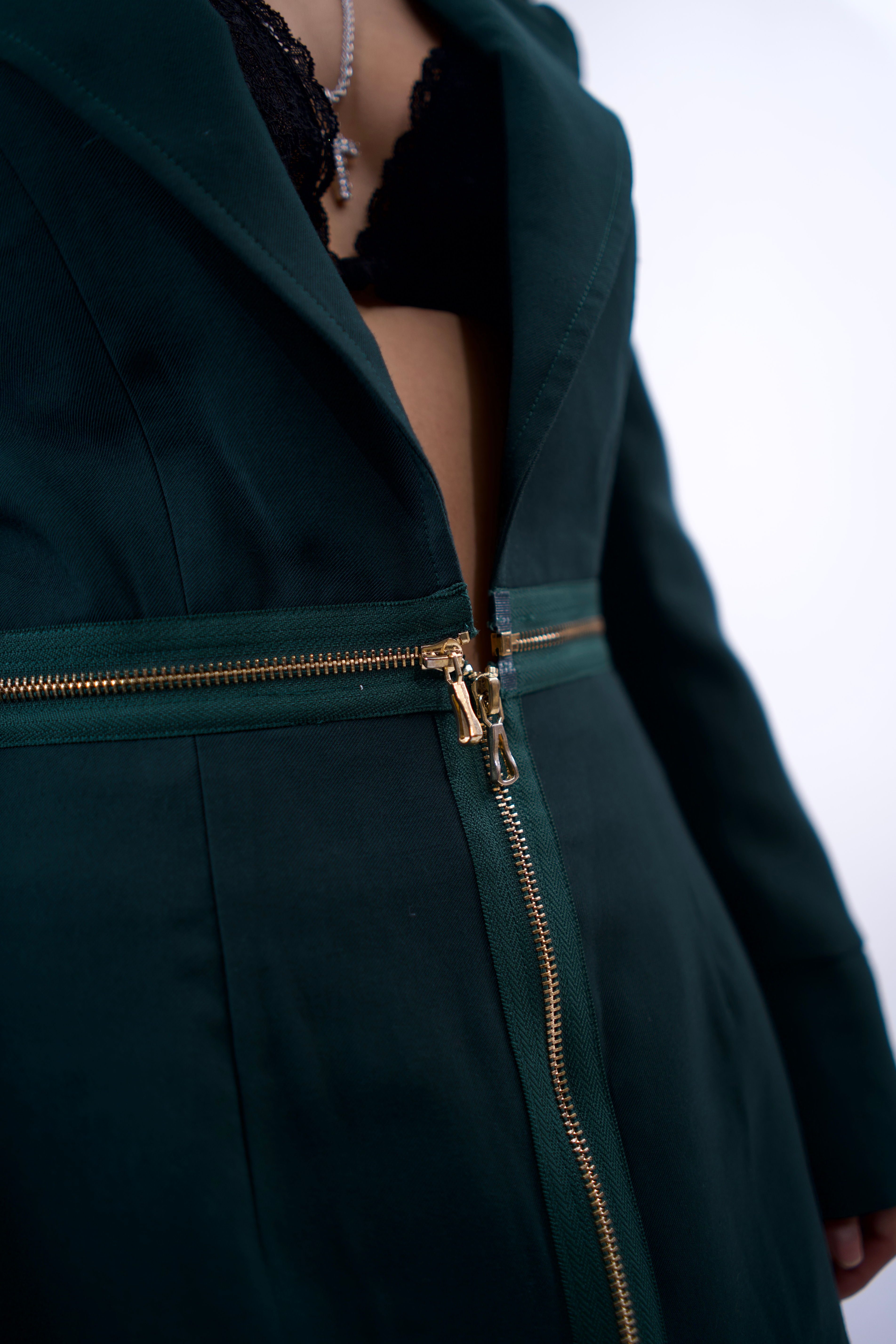 Green coat with a gold zipper on a white background