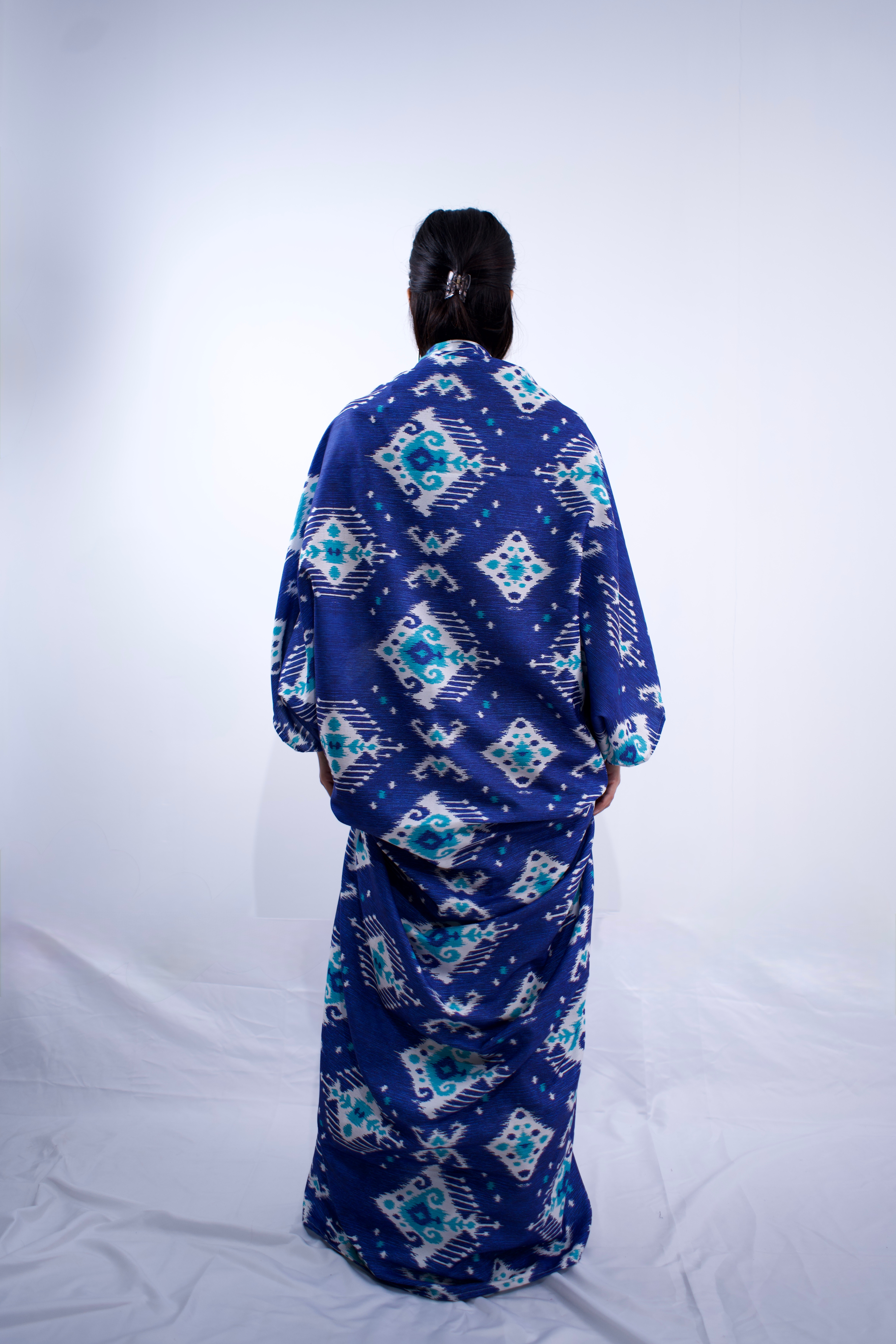 Person wearing a blue patterned garment on a white background