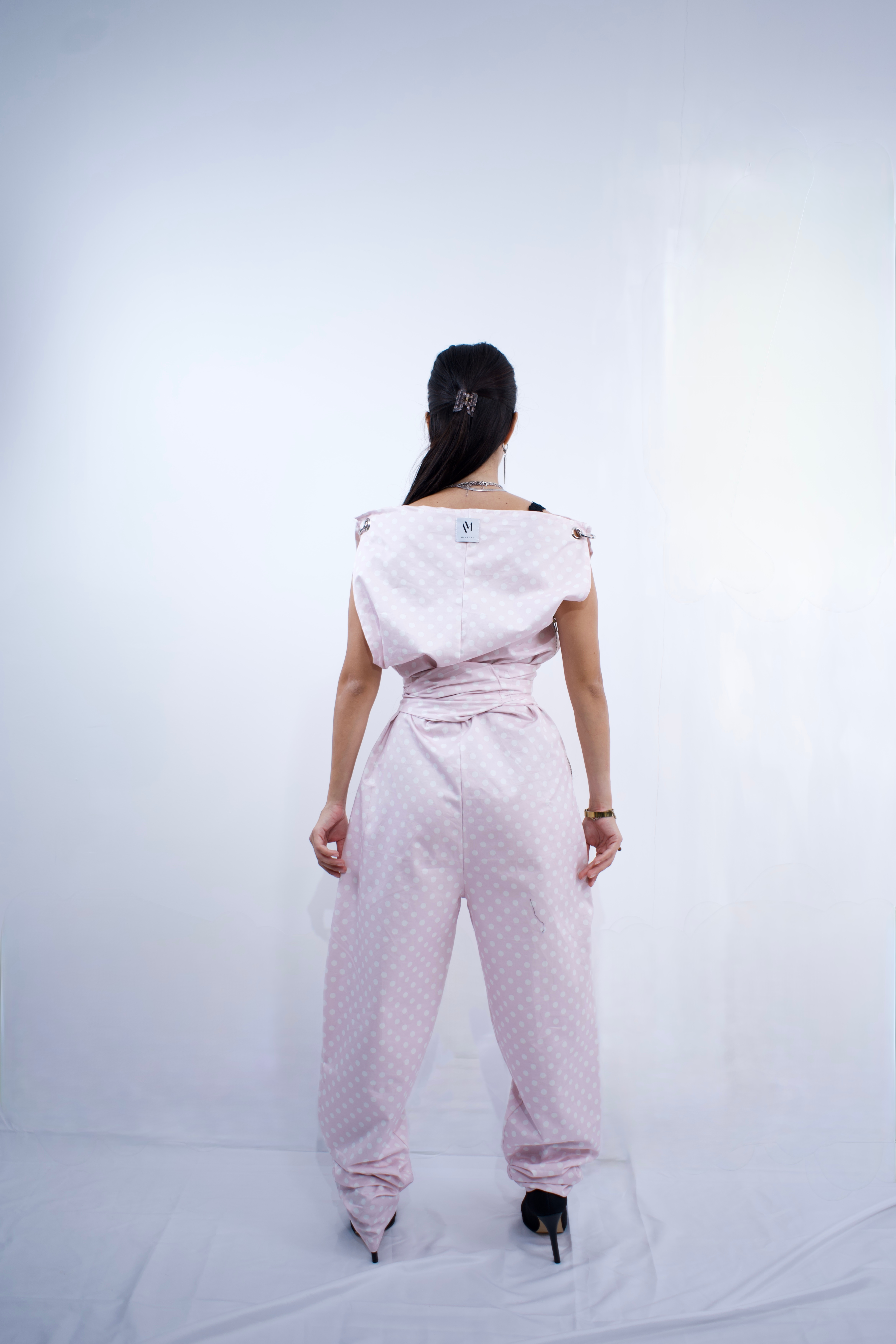 Switch Jumpsuit by MVATIS a convertible jumpsuit that transforms into sleek trousers with adjustable belt detail for cinched waist effect.