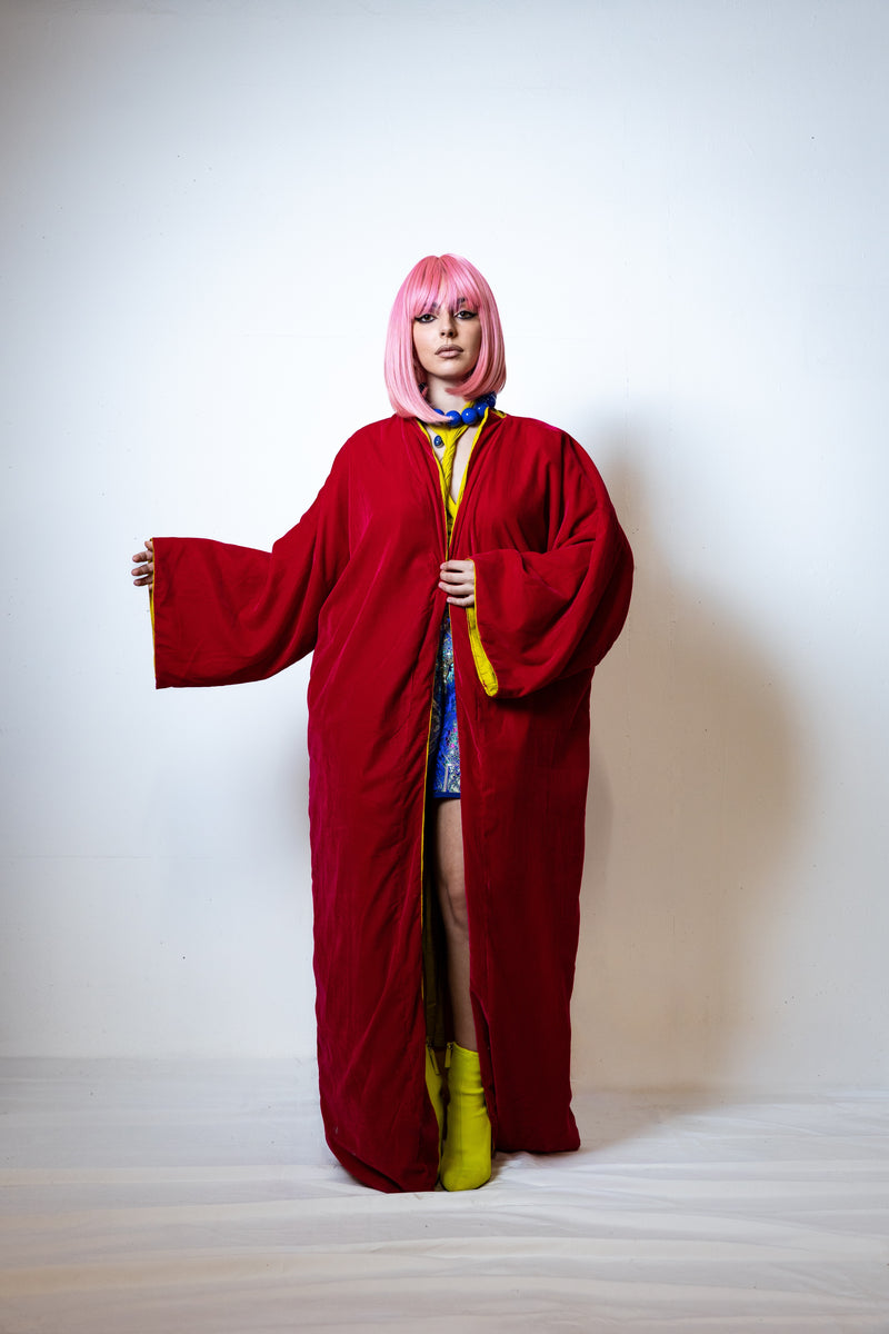 Person wearing a red robe with a white background