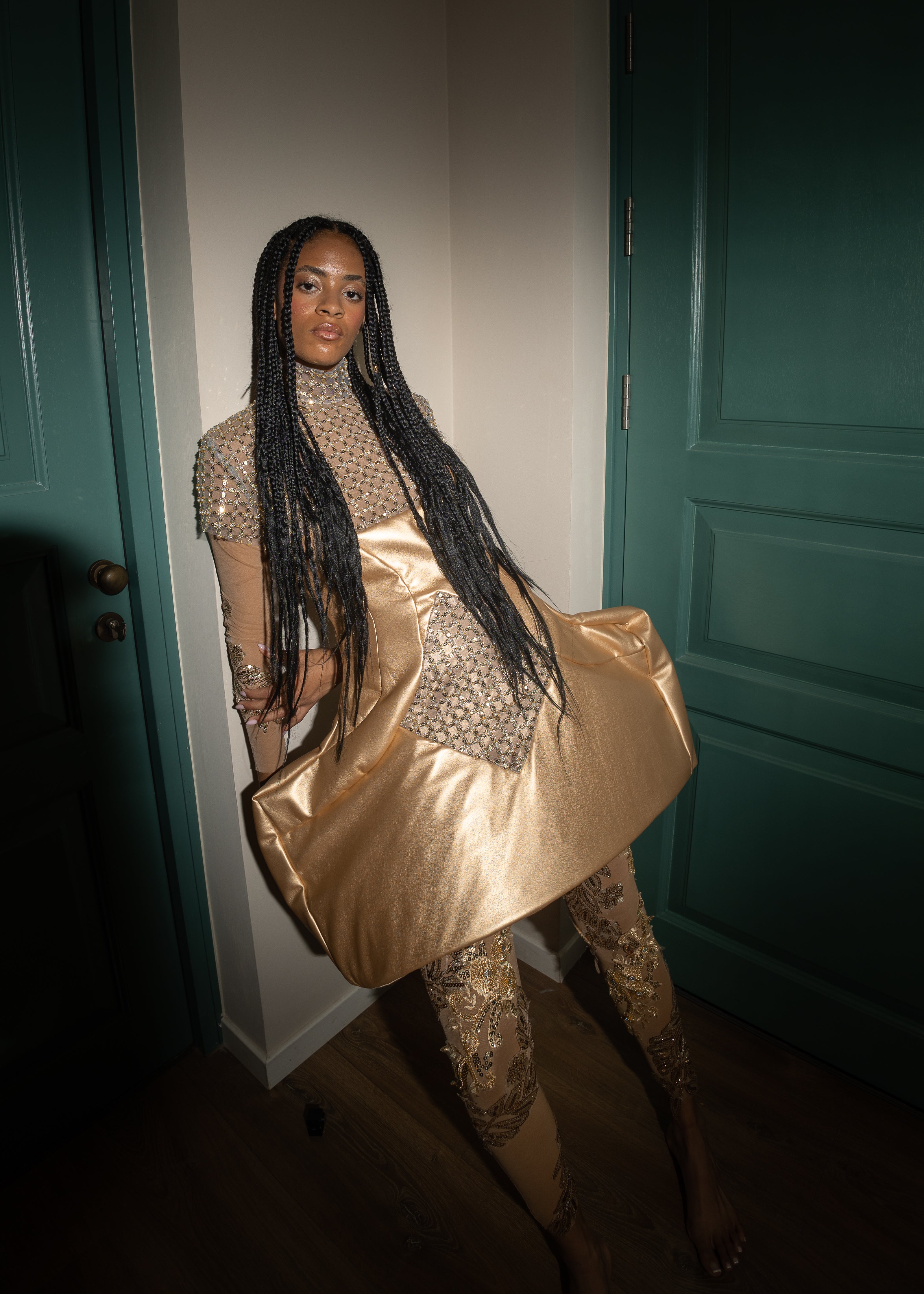 “Sculpted gold faux leather mini dress with intricate beading, featuring a form-fitting silhouette, structured bodice, and a glossy finish designed for the red carpet.”