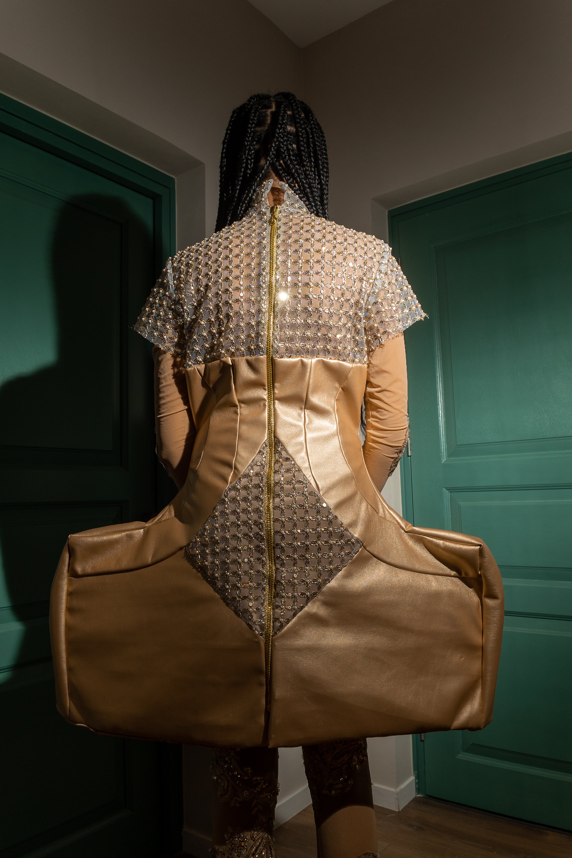 “Sculpted gold faux leather mini dress with intricate beading, featuring a form-fitting silhouette, structured bodice, and a glossy finish designed for the red carpet.”