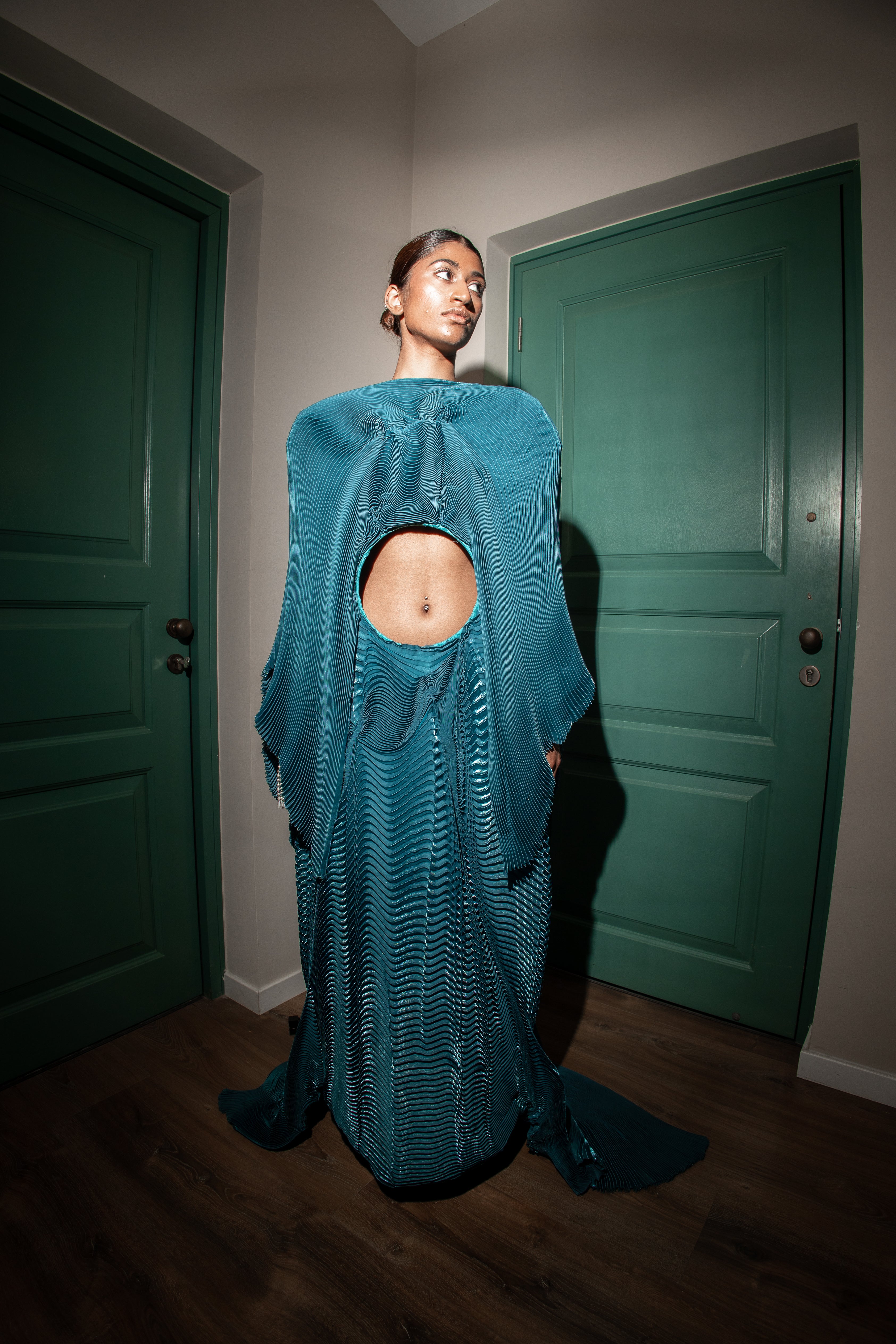 Teal accordion pleated dress with hand-stitched detailing and a distinctive circular design at the center.
perfect for red carpet