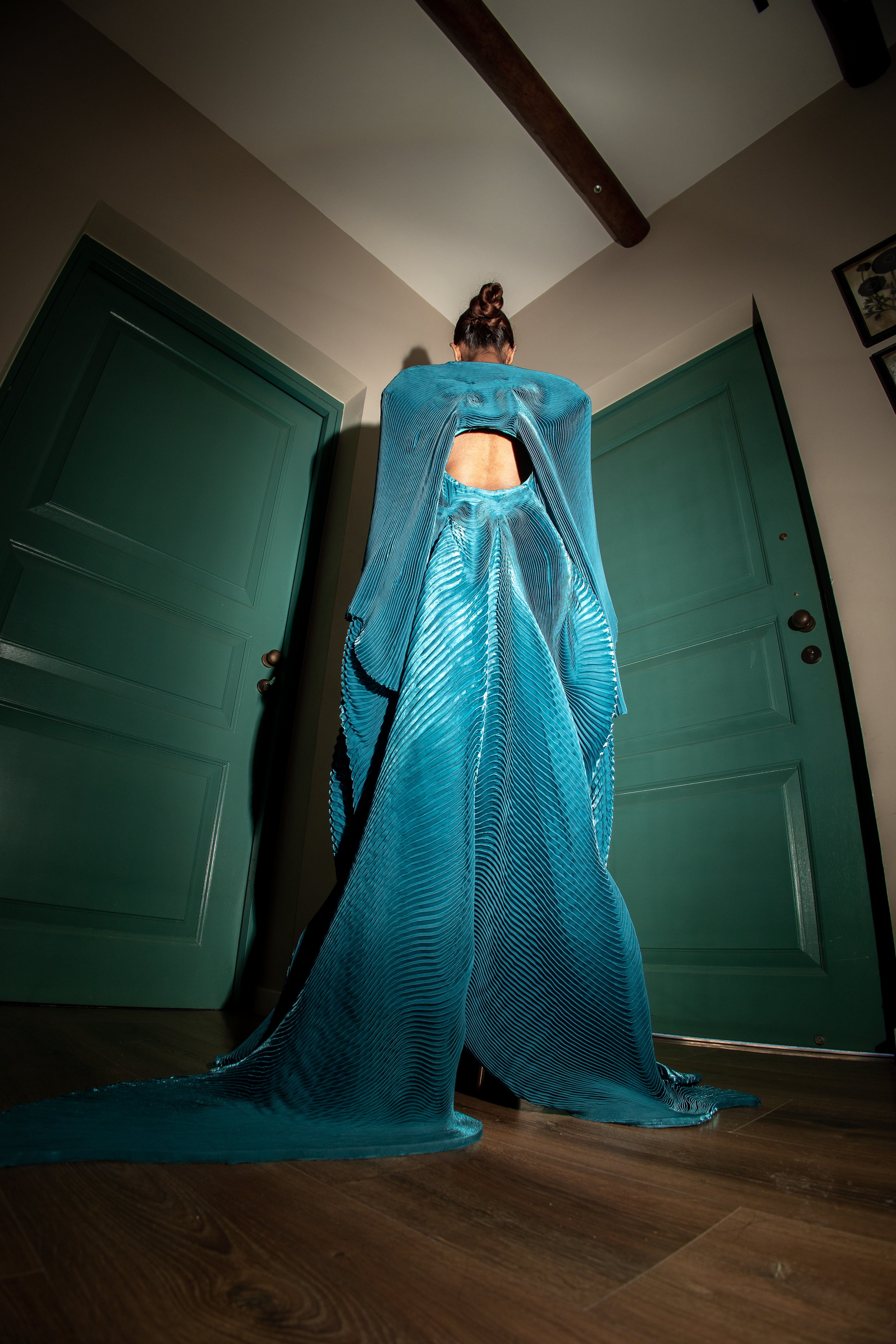  Teal accordion pleated dress with hand-stitched detailing and a distinctive circular design at the center.
red carpet events