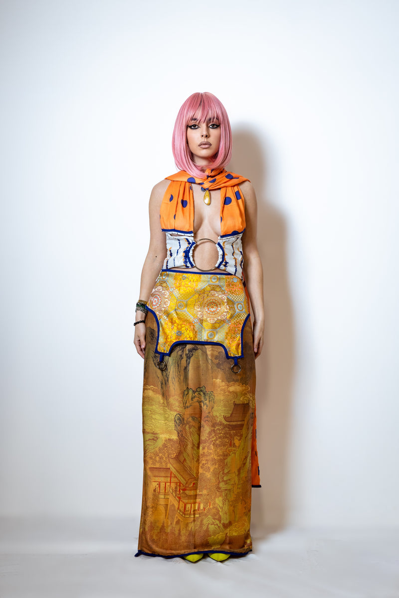 Person wearing a colorful dress with a patterned scarf on a white background